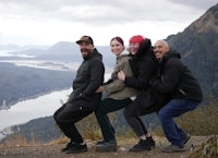 a group of people posing on top of a mountain