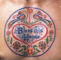 a man with a tattoo on his chest that says bless the house