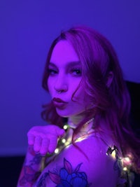 a woman with tattoos posing in a dark room