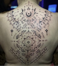 a woman's back with a tattoo on it