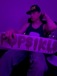 a man sitting in a chair holding a skateboard