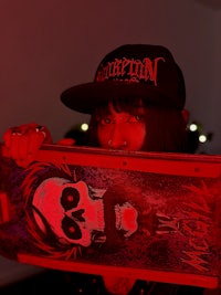 a woman holding a skateboard with a skull on it