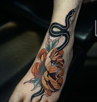 a foot tattoo with an orange flower and a snake