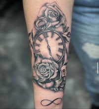 an infinity tattoo with roses and a clock